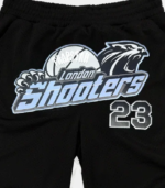 Black and ice blue Trapstar Shooters SS23 Basketball shorts featuring signature Shooters branding, an elastic waistband, side pockets, and a relaxed athletic fit.